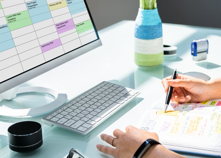 Cortney Duval sitting at a desk with a planner in hand and computer calendar open