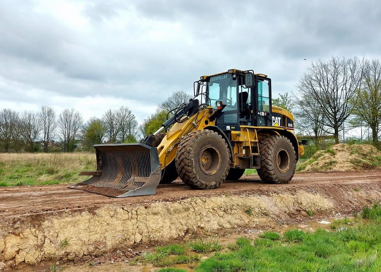 a tractor with a loader on a dirt road