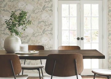 Modern dining room featuring floral wallpaper, a wood table, and mid-century chairs by French doors.