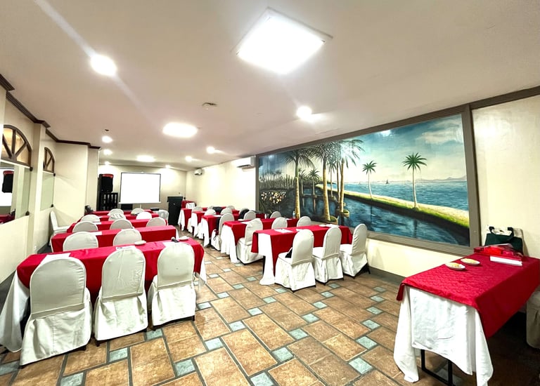 a meeting room with tables and chairs and red tablecloth a projector