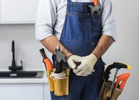 Hausmeister in Arbeitskleidung mit Werkzeuggürtel – Symbolbild für vielfältige