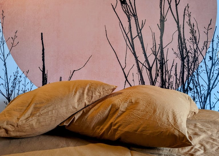 un lit avec une literie orange et une tête de lit ensoleillée