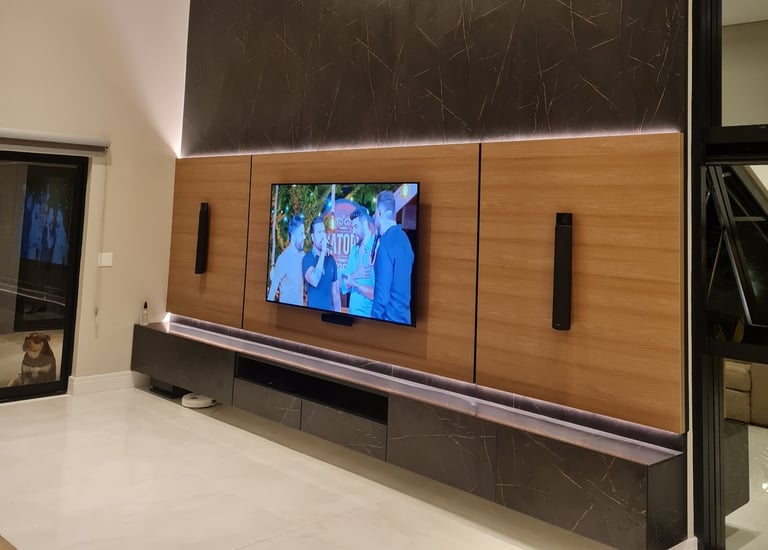 Sala de estar moderna com TV fixada na parede em um painel MDF madeirado e MDF que imita mármore
