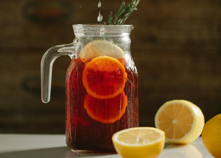 a person squeezing lemonade into a jar of lemonade