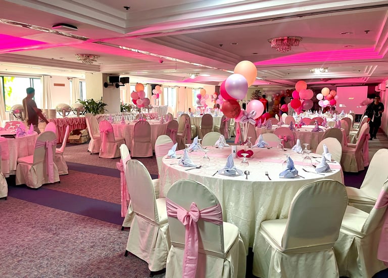 a function room with a table and chairs and balloons for birthday celebration