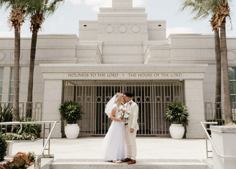 a bride and groom standing in front of a temple