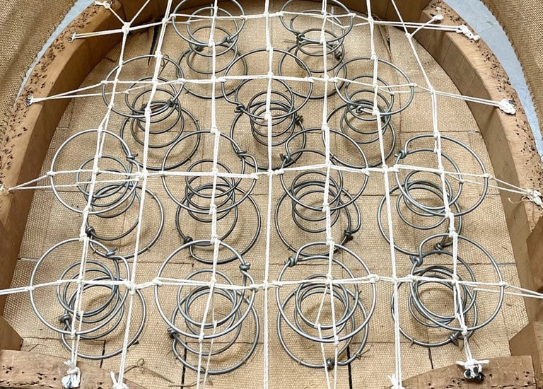 Carcasse d'un fauteuil crapaud avec sur le sanglage des ressorts guindés par des cordes