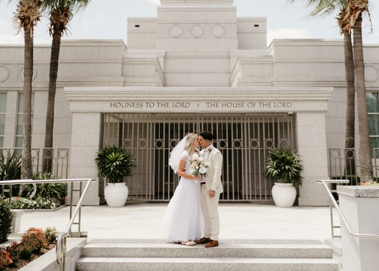 a bride and groom standing in front of a temple
