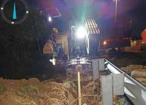 a construction site with a construction worker on the side of the road