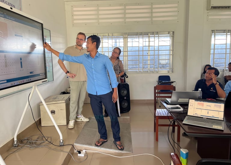 a man standing in front of a large screen teachning
