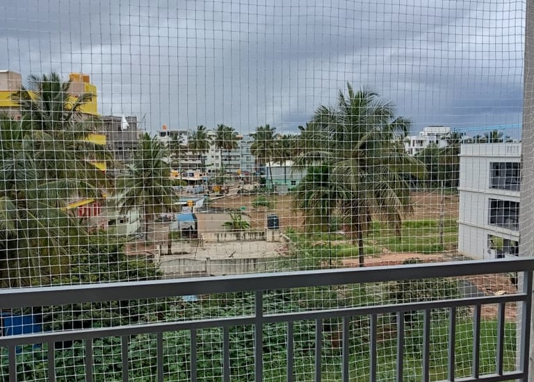 Wide shot of a balcony fully covered with pigeon netting under bright sunlight.