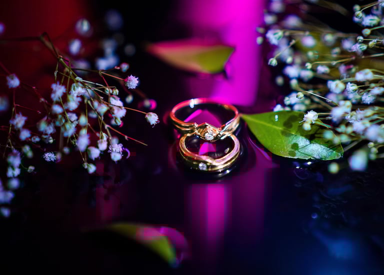 two wedding rings with flowers and a bouquet