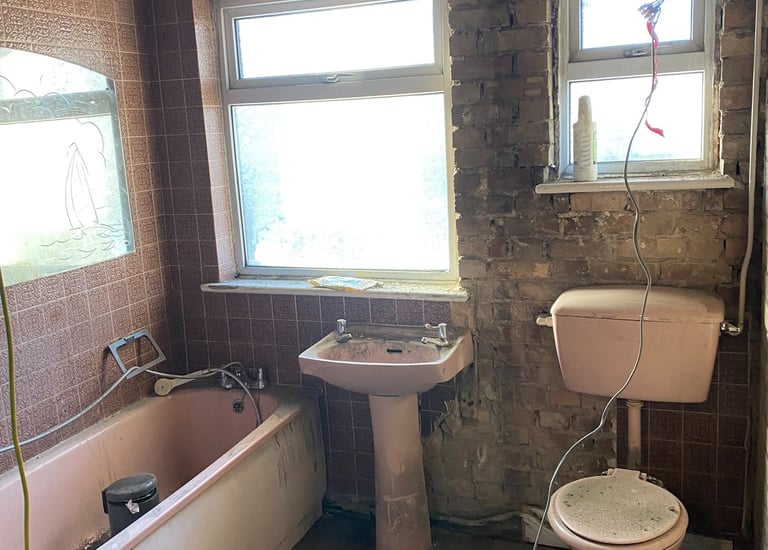 a derelict bathroom with a toilet and a sink