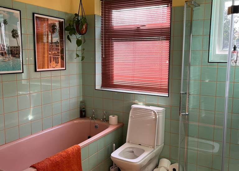 a bathroom with a pink bathtub and a pink bathtub