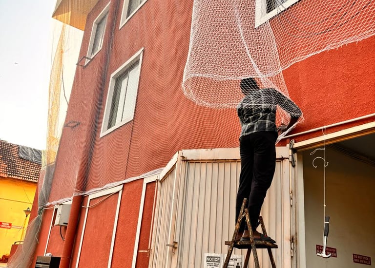 Wide shot showing pigeon nets covering windows in a nagawara residential complex.