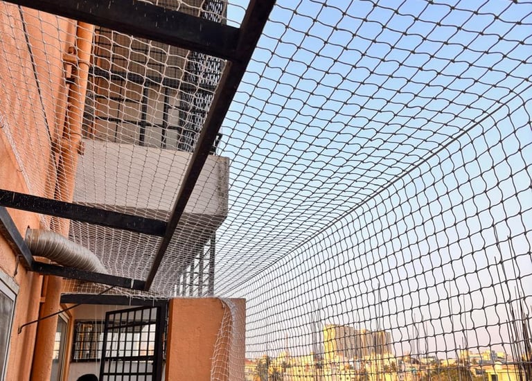 Close-up of a sturdy balcony safety net installed on a high-rise apartment in Chennai.