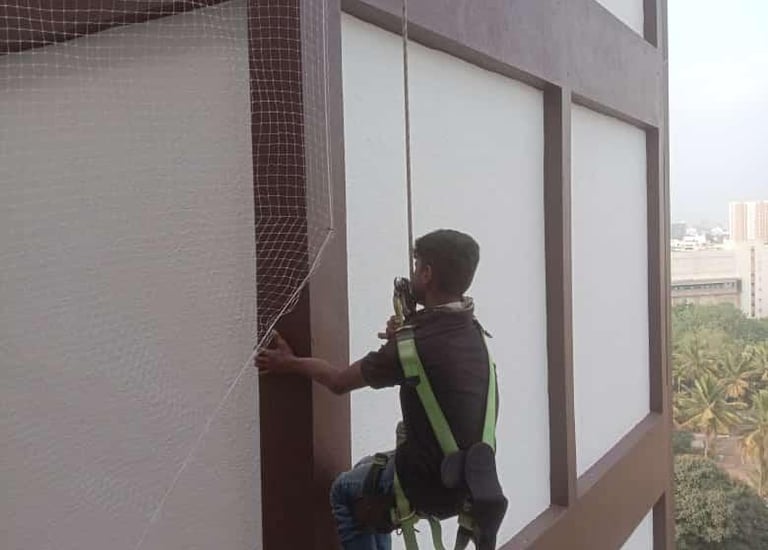 Technician carefully measuring balcony dimensions for net installation