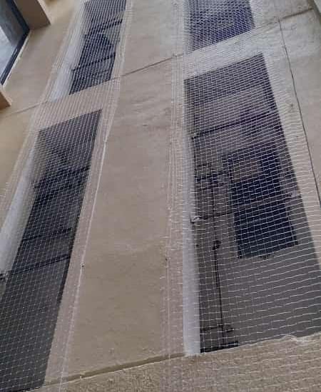 Wide shot of an apartment balcony fully covered with pigeon netting.