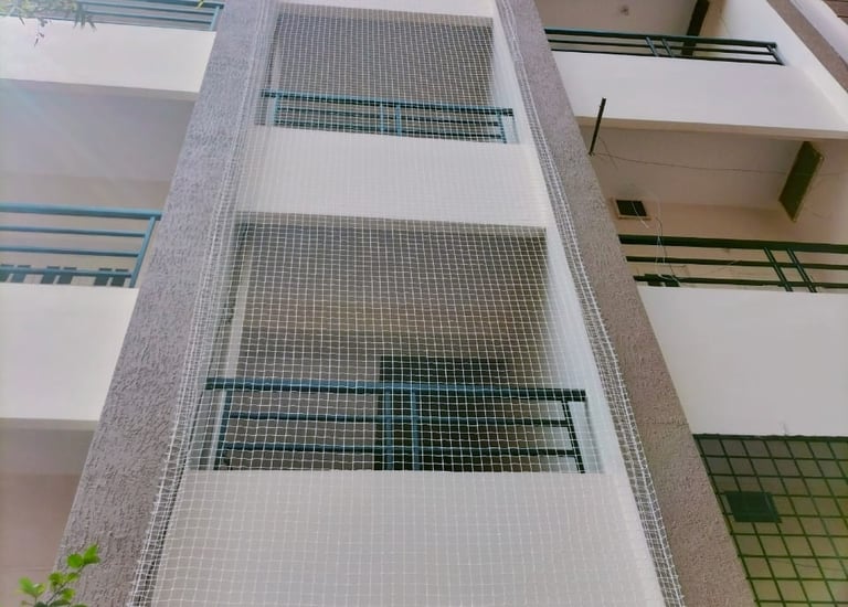 Close-up of a sturdy pigeon net securely fitted around an apartment duct area in Perungudi.