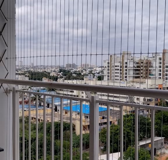 Close-up of a sleek invisible grill installed on a T Nagar balcony, blending seamlessly with the sur