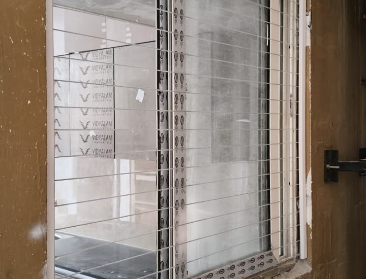 Installation team from Arjilli Enterprises fitting invisible grills on a Royapettah home.