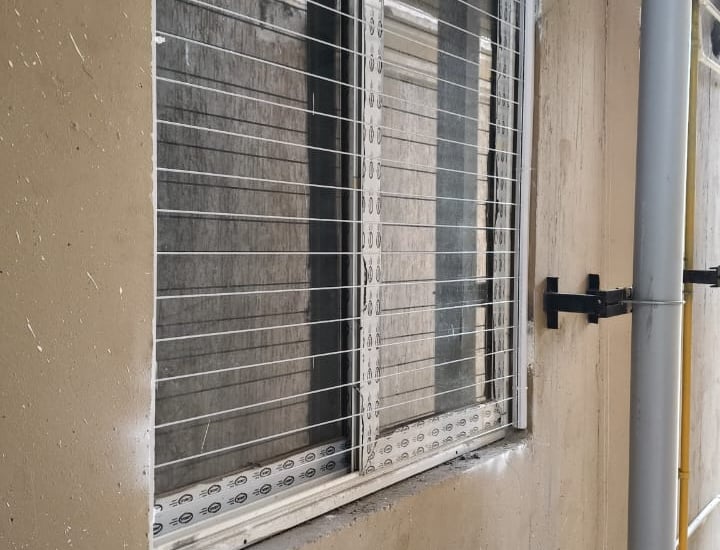 Wide shot of a modern apartment window featuring invisible grills by Arjilli Enterprises.