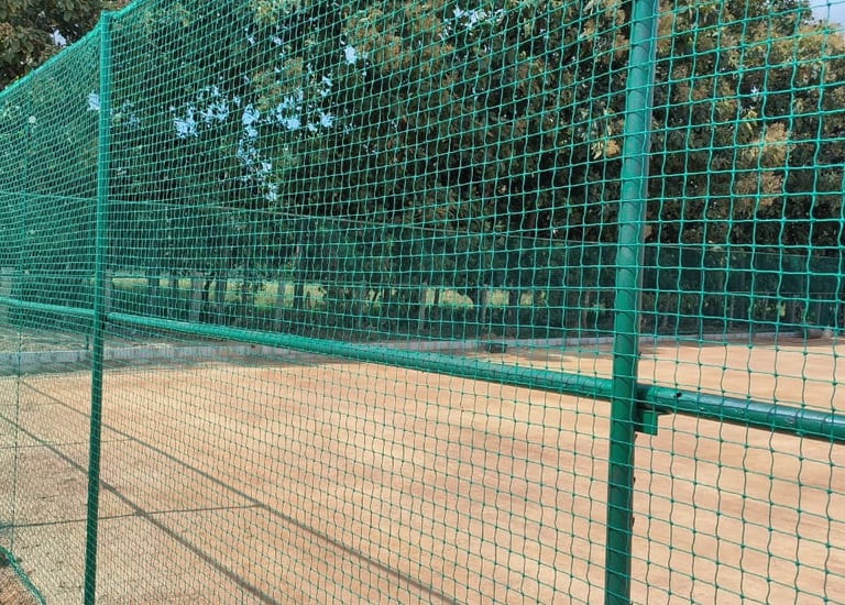 Volleyball net installed on a rooftop with cityscape background.