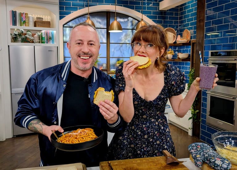 Dan Clapson eating Heated Rivalry inspired tuna melts with Mary Berg on The Good Stuff