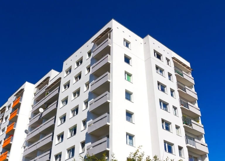 a tall white building with a blue sky in the background