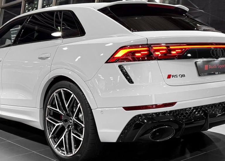 Rear view of a white Audi RS Q8 luxury SUV featuring LED taillights and sporty dual exhaust.