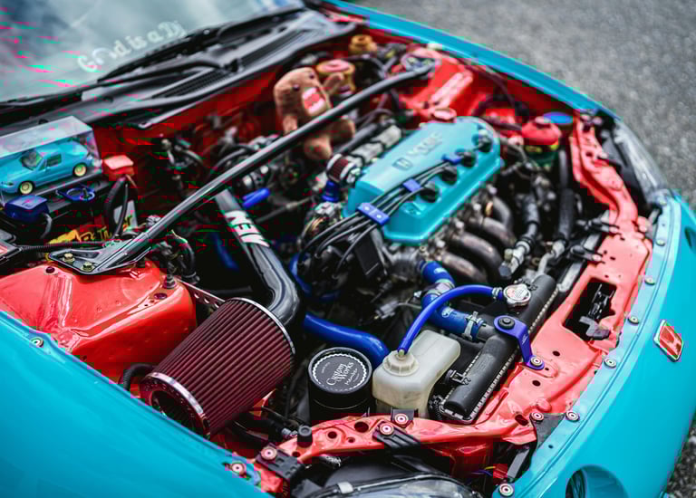 Stage 2 Remap A high-angle shot of a custom-tuned Honda engine bay featuring a vibrant red air filte