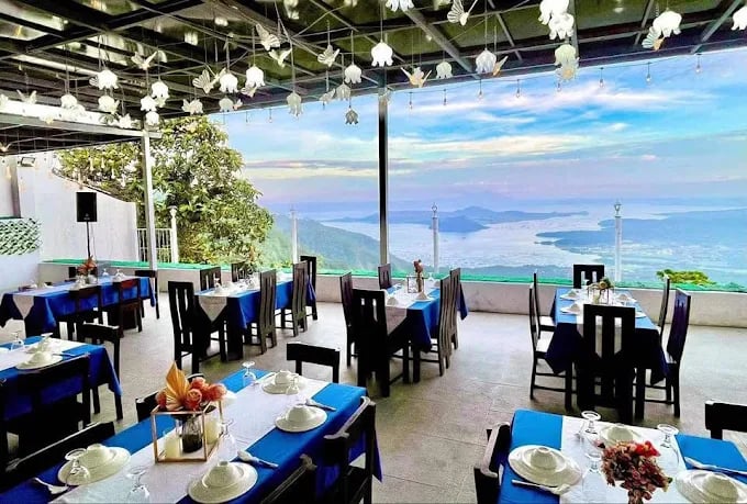 a restaurant with blue tables and chairs and a view of the ocean