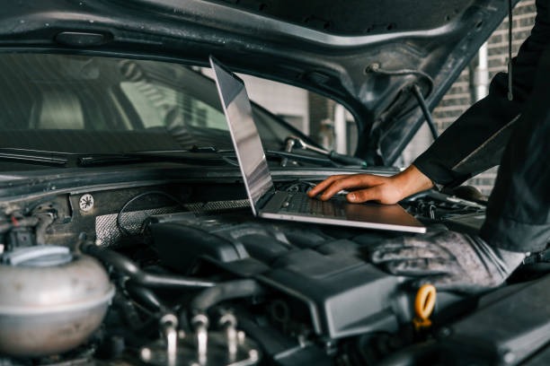 a man working on a laptop computer in a garage