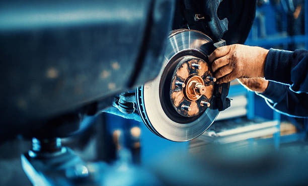 a man working on a car's brake disc