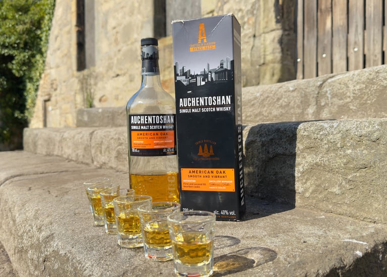 glasses of whisky in front of a bottle of whisky