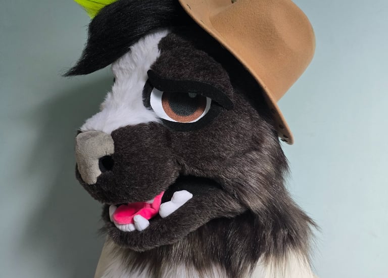 Custom skunk furry head mask with neon green hair wearing a miniature cowboy hat.