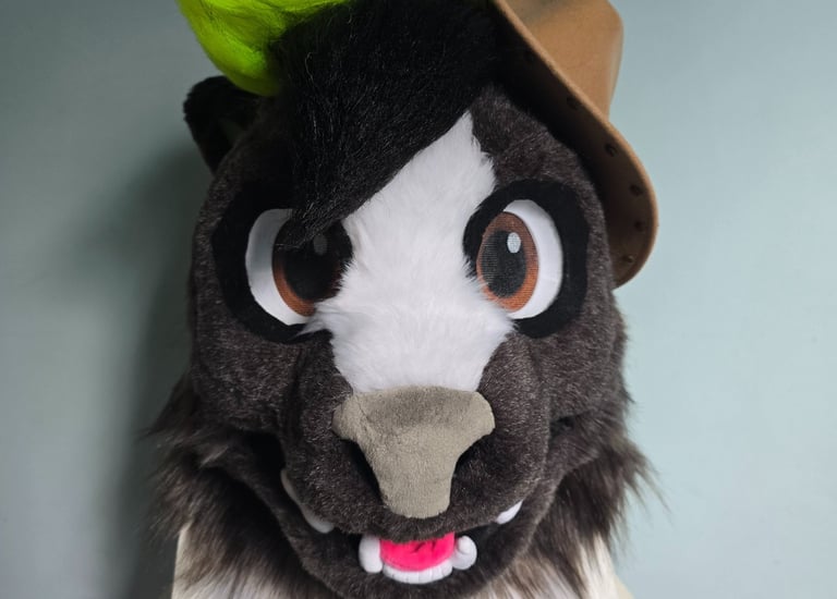 Custom furry skunk fursuit head featuring dark fur, neon green hair, and a brown cowboy hat.