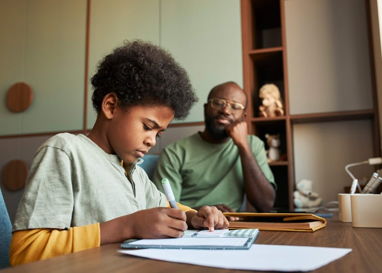 Un papa assistant à l'exécution des exercices à domicile de son fils.  Tolanda, suivi scolaire