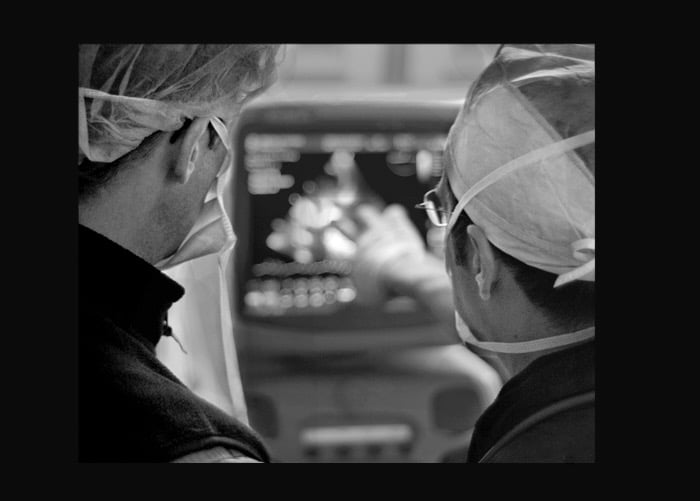 Instructor discussing an ultrasound image during a hospital procedure.