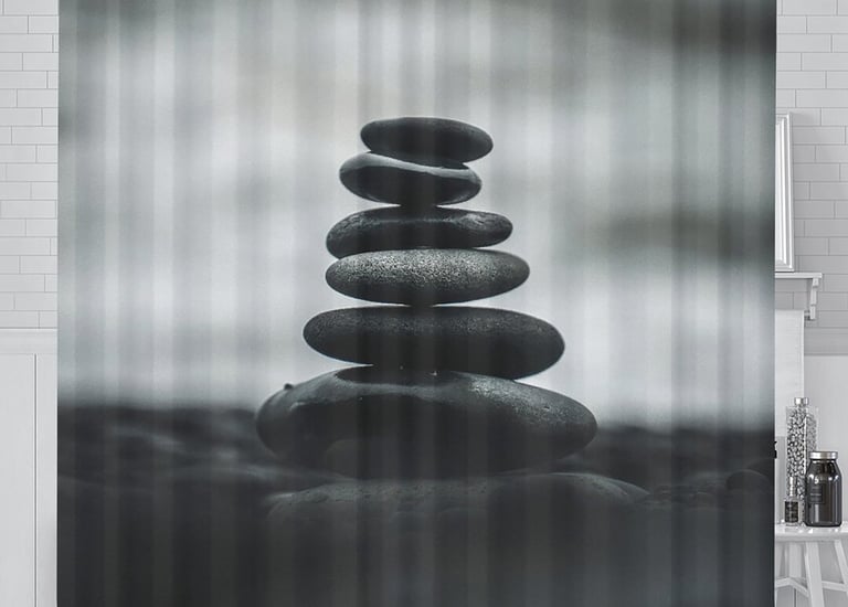 a black and white shower curtain with a stack of rocks
