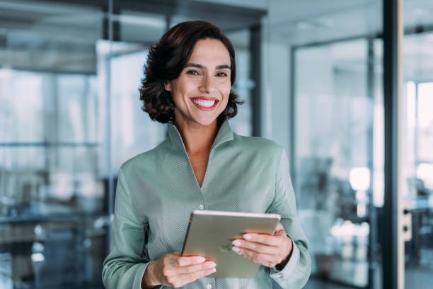 a smiling woman holding a tablet computer and smiling