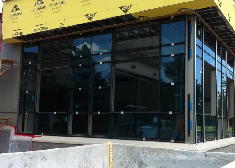 Commercial storefront under construction with modern glass windows and black frames