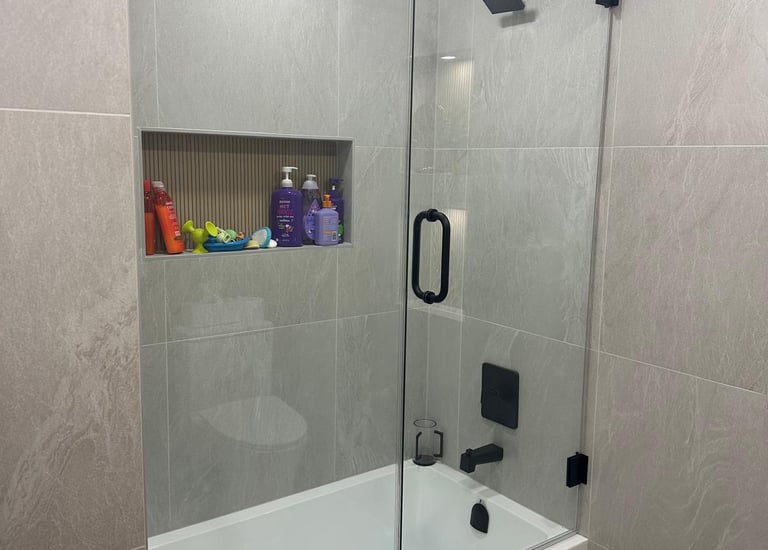 Frameless glass shower door installation with chrome hardware and modern design