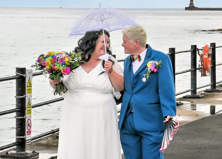 Happy Couple just married walking along the sea shore