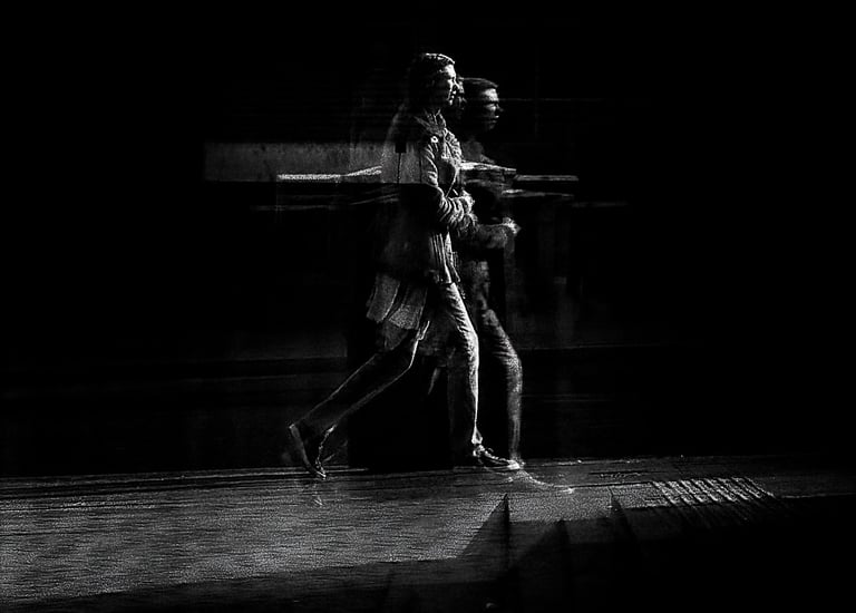 Two people walking, distorted through glass. The Usher Hall, Edinburgh