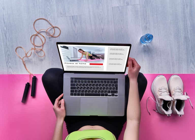 a woman sitting on a yoga mat with a laptop