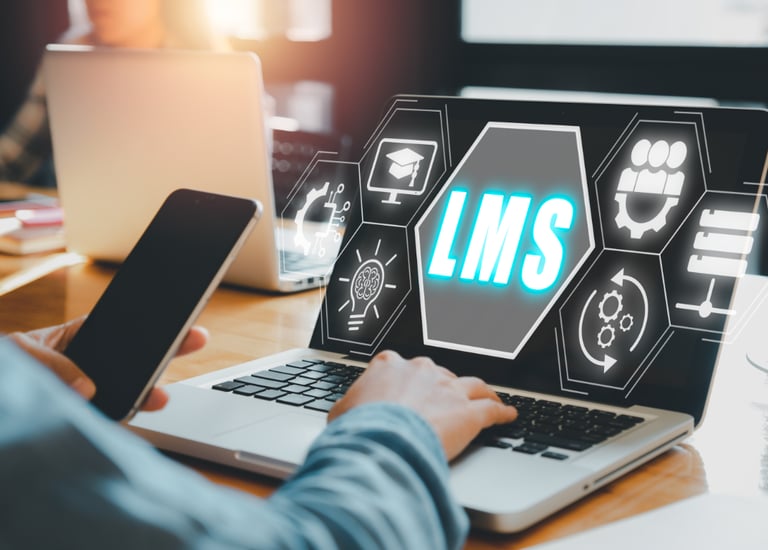 A glowing interface-style graphic reading LMS, rising off of a laptop screen.