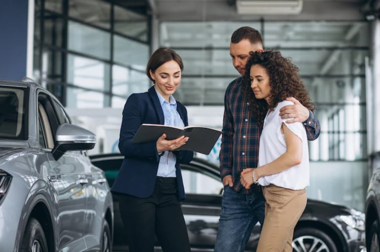 медеджер з продажу автодилера спілкується з клієнтами