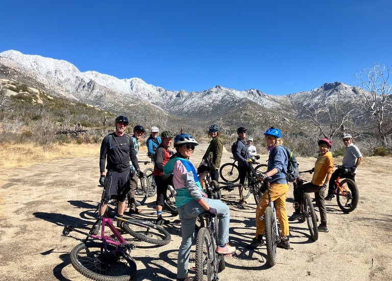 a group of people standing around a group of bikes