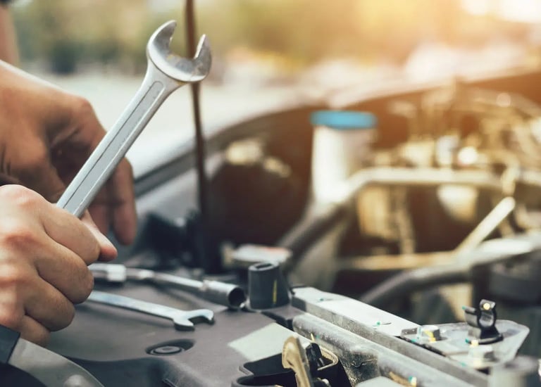 a man working on a car with a wrench